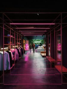 Interior of a modern clothing store in Antwerp, featuring neon pink lights and a sleek design.